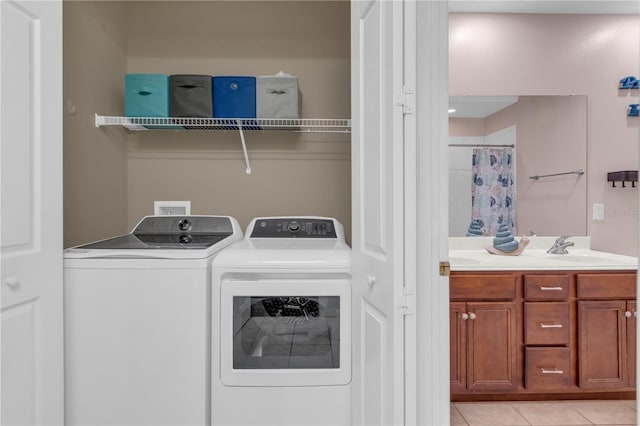 laundry area featuring washer and clothes dryer, sink, and light tile patterned floors