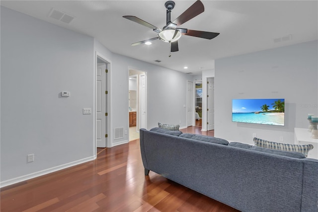 living room with ceiling fan and dark wood-type flooring