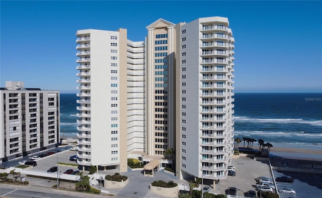 view of property with a water view and a view of the beach