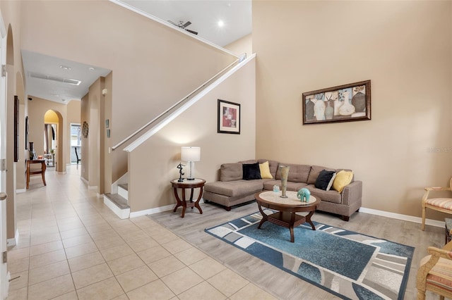 living room featuring a towering ceiling and light tile patterned floors