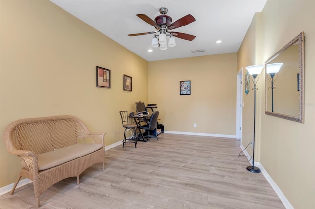 living area featuring light wood-type flooring and ceiling fan