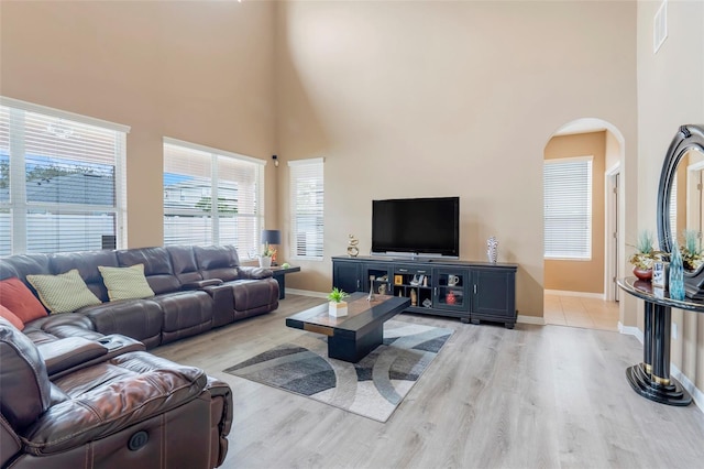 living room featuring light hardwood / wood-style floors and a high ceiling