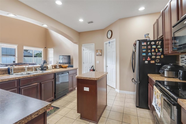 kitchen with sink, light tile patterned floors, black appliances, and a center island