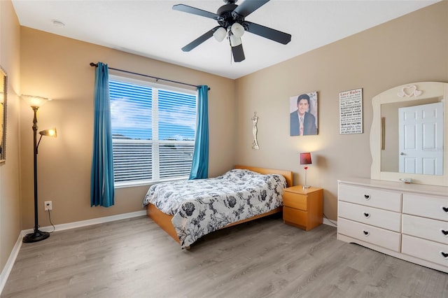 bedroom with light wood-type flooring, ceiling fan, and multiple windows