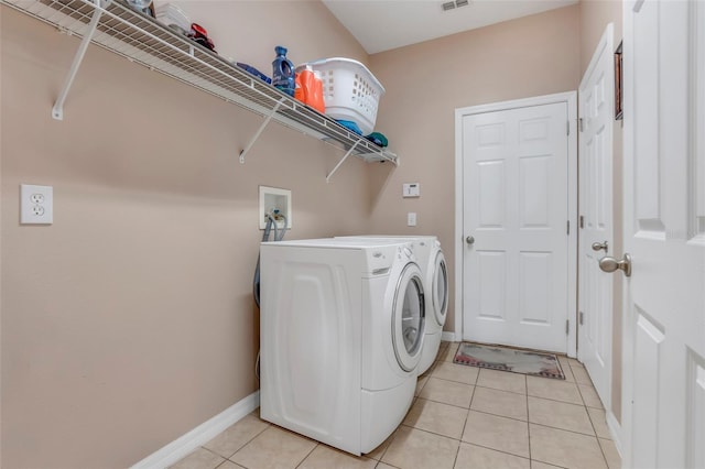 laundry room featuring washing machine and dryer and light tile patterned flooring