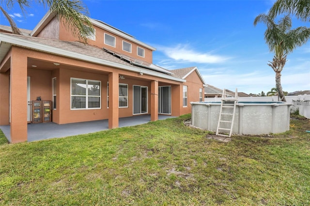 back of property featuring a patio and a lawn