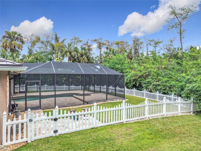 view of yard with a fenced in pool, a patio, and glass enclosure