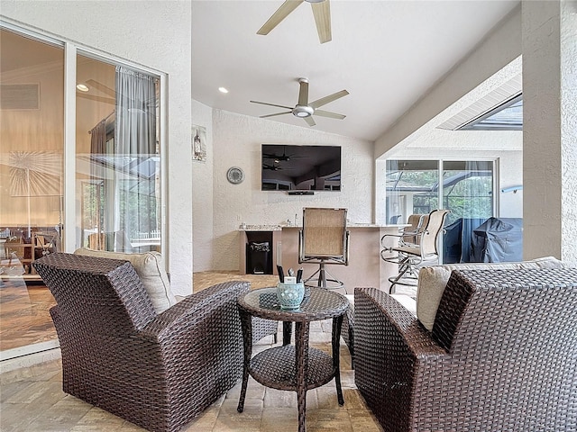 living room with ceiling fan and vaulted ceiling