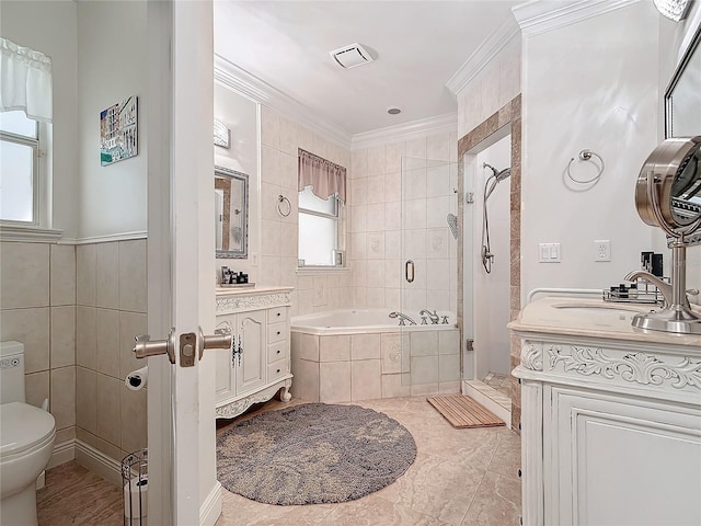 full bathroom with vanity, tile walls, toilet, crown molding, and independent shower and bath