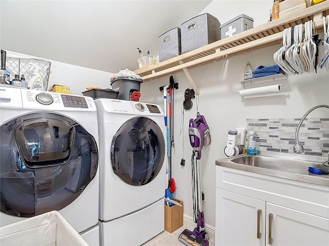 laundry room with cabinets, sink, and washing machine and dryer