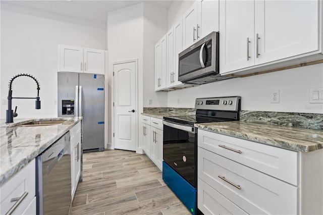 kitchen featuring white cabinets, stainless steel appliances, and sink