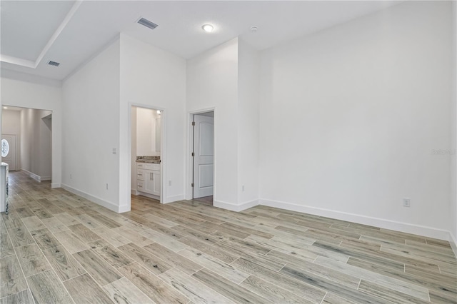 unfurnished bedroom with a high ceiling and ensuite bath