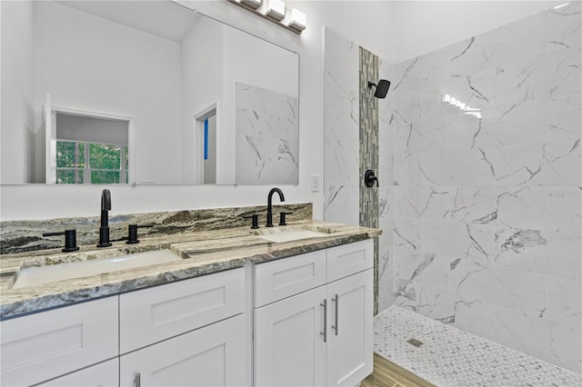 bathroom with a tile shower, wood-type flooring, and vanity