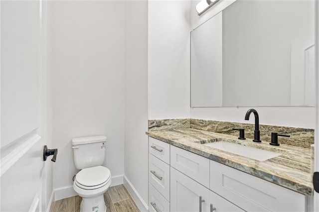 bathroom featuring toilet, hardwood / wood-style floors, and vanity