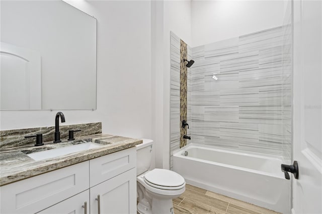 full bathroom featuring vanity, tiled shower / bath combo, and toilet