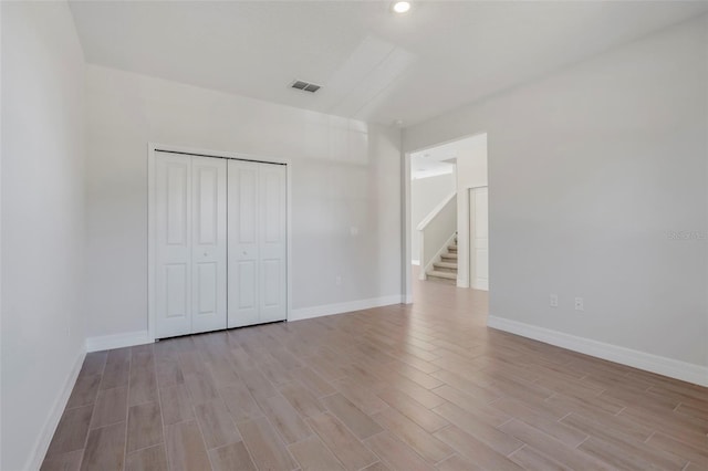 unfurnished bedroom featuring baseboards, visible vents, and light wood-style floors