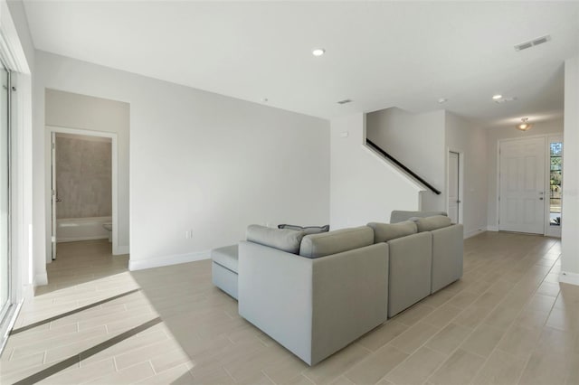 living room featuring recessed lighting, visible vents, light wood finished floors, and baseboards