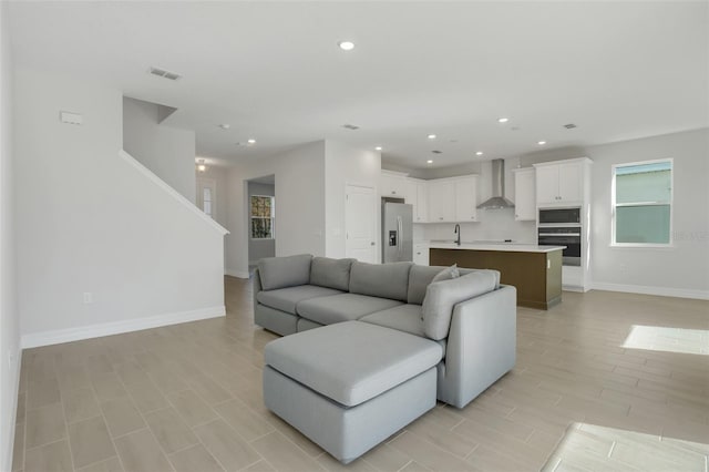 living area featuring baseboards, visible vents, and recessed lighting