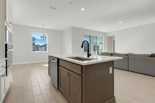 kitchen featuring stainless steel appliances, a sink, light countertops, and white cabinets