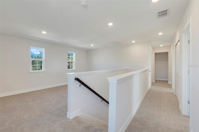 corridor with visible vents, recessed lighting, an upstairs landing, and light colored carpet