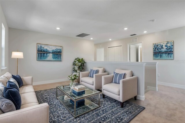 living area with light colored carpet, recessed lighting, visible vents, and baseboards