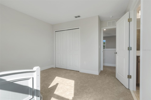 unfurnished bedroom featuring baseboards, visible vents, and light colored carpet