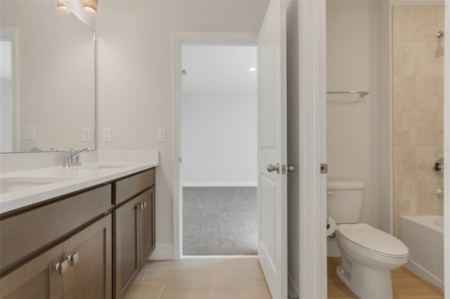 full bathroom with double vanity, shower / washtub combination, a sink, and toilet