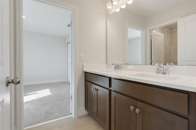 full bathroom featuring a sink, baseboards, and double vanity