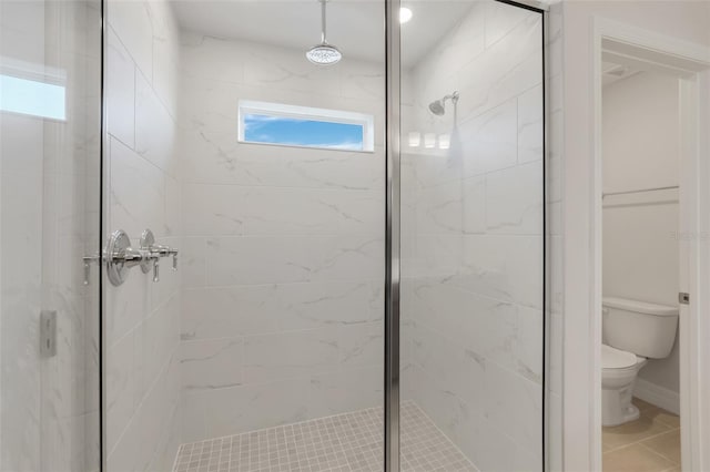 full bathroom with a shower stall, toilet, and tile patterned floors