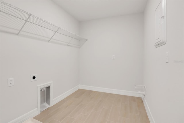 laundry area with laundry area, baseboards, light wood finished floors, and hookup for an electric dryer