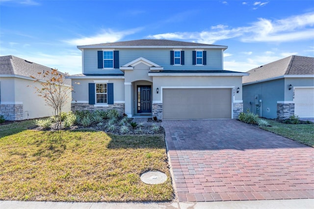 view of front of property featuring an attached garage, stone siding, decorative driveway, stucco siding, and a front lawn