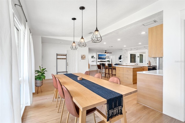 dining space with ceiling fan, a healthy amount of sunlight, light hardwood / wood-style flooring, and sink