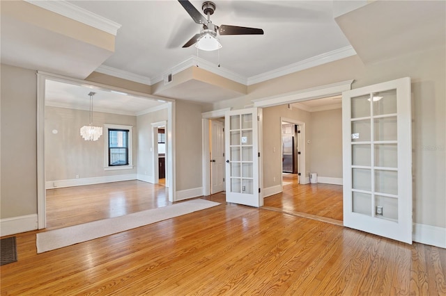 unfurnished room featuring french doors, ceiling fan with notable chandelier, ornamental molding, and hardwood / wood-style floors