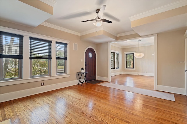 foyer featuring hardwood / wood-style flooring, ornamental molding, and ceiling fan with notable chandelier