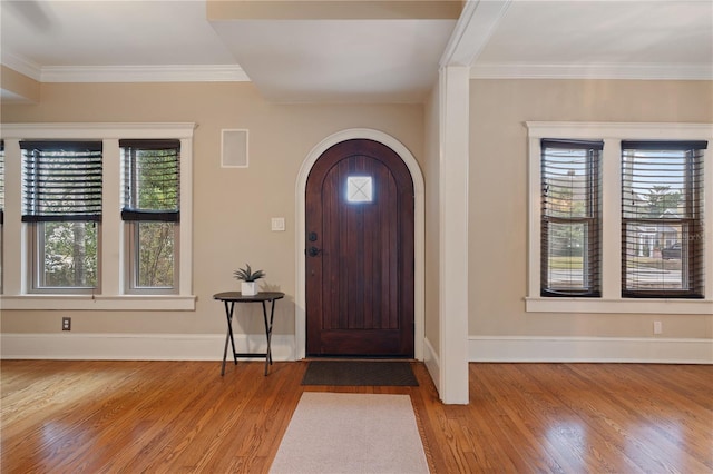 foyer featuring a healthy amount of sunlight, light wood-type flooring, and ornamental molding