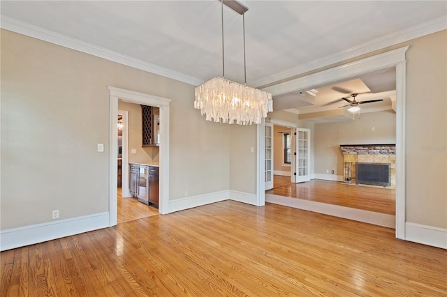 interior space featuring light wood-type flooring, crown molding, and ceiling fan with notable chandelier