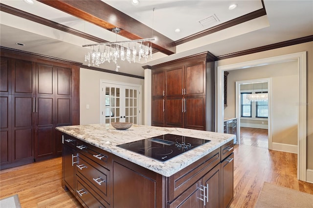 kitchen featuring black electric stovetop, pendant lighting, light hardwood / wood-style floors, a center island, and ornamental molding