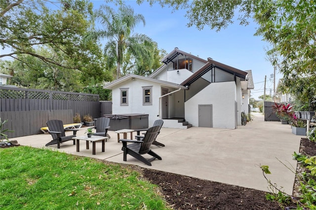 back of house featuring a hot tub and a patio