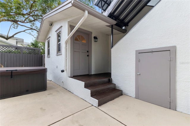 entrance to property featuring a patio area and a hot tub