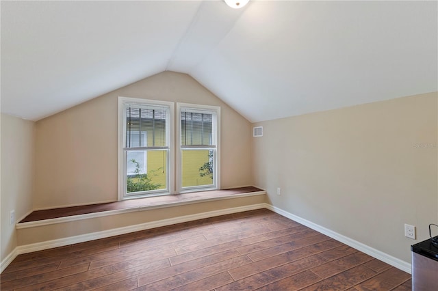 bonus room with vaulted ceiling and dark wood-type flooring