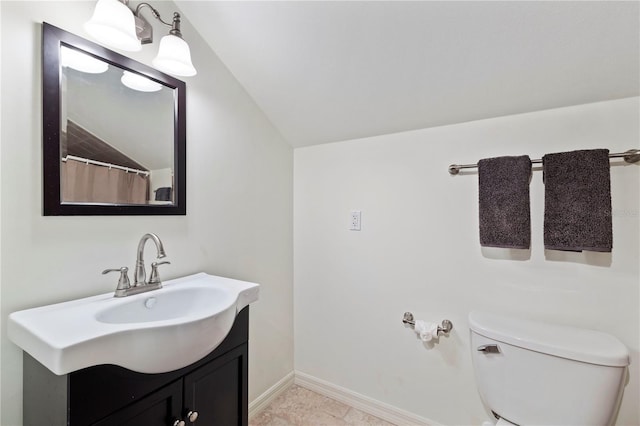 bathroom featuring tile patterned flooring, toilet, vanity, and vaulted ceiling