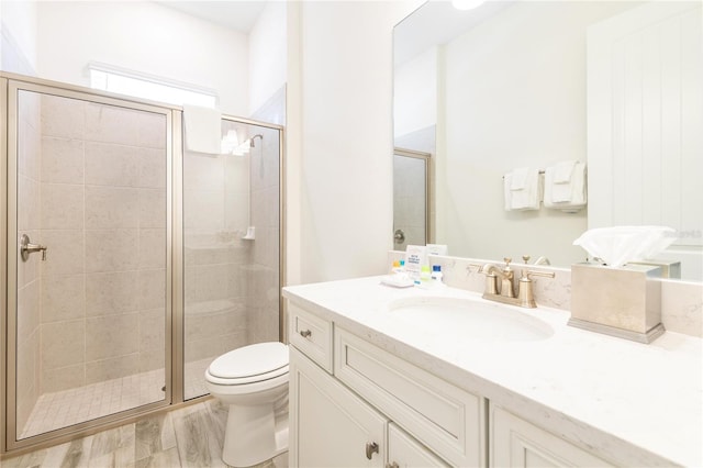 bathroom featuring a shower with door, toilet, vanity, and wood-type flooring