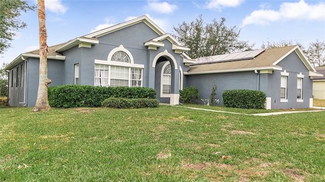 view of front of home featuring a front yard and solar panels