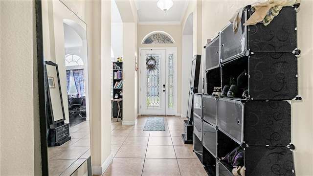 foyer entrance featuring light tile patterned floors and ornamental molding