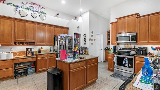 kitchen featuring light tile patterned floors, light stone countertops, a high ceiling, and stainless steel appliances