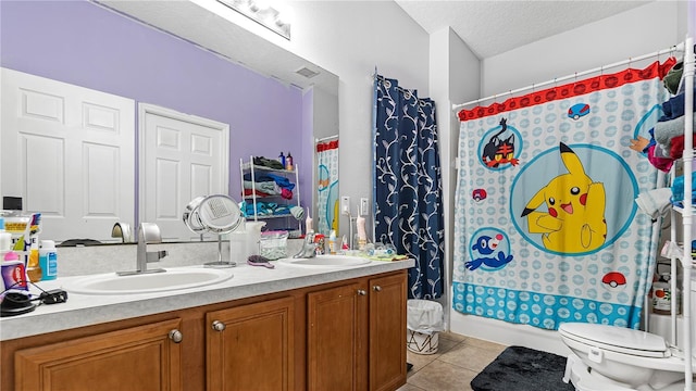 full bathroom with a textured ceiling, tile patterned flooring, vanity, toilet, and shower / bath combo with shower curtain