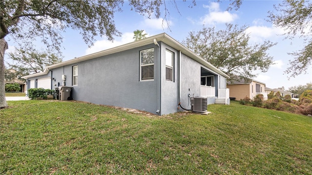 view of side of home featuring central AC unit, a garage, and a yard