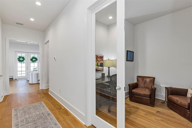 hallway featuring french doors and light wood-type flooring