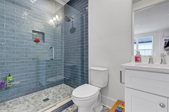 bathroom featuring a shower with shower door, vanity, tile patterned floors, and toilet