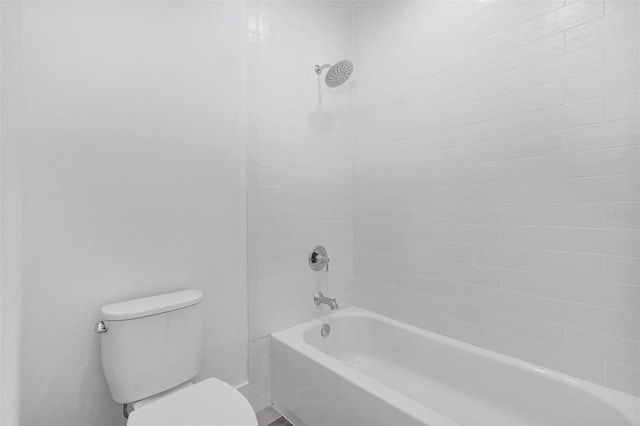 bathroom with toilet and tiled shower / bath combo